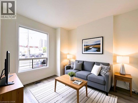 A living room with a grey couch, a wooden coffee table, and a painting on the wall.