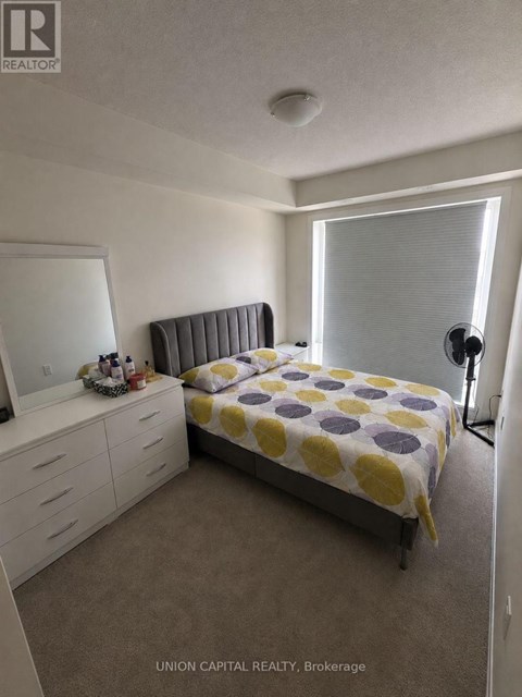 A bedroom with a bed, dresser, and mirror.