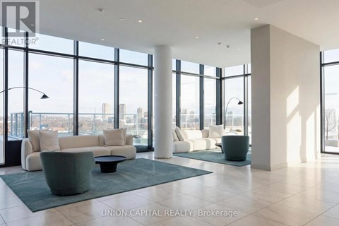A spacious living room with a view of the cityscape outside the large windows.