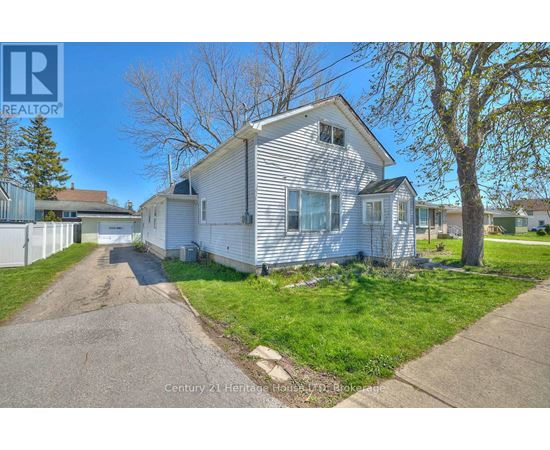 A white house with a grey roof is for sale.