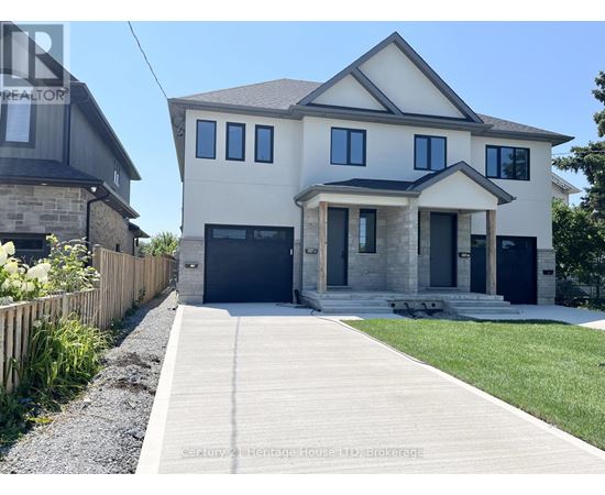 A modern house with a grey garage door and a wooden fence.