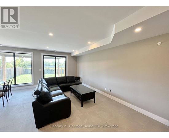 A spacious living room with a black leather sofa and a coffee table.