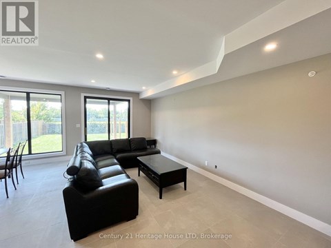 A spacious living room with a black leather sofa and a coffee table.