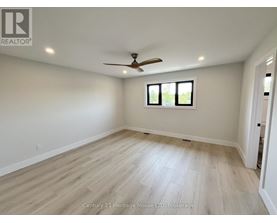 A spacious room with a ceiling fan and a window.
