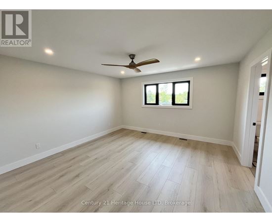 A spacious room with a ceiling fan and a window.