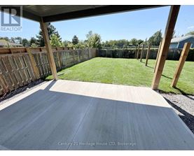 A wooden deck with a fence and grassy area in the background.