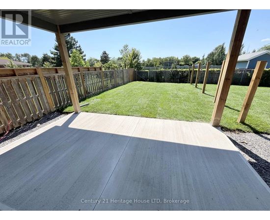 A wooden deck with a fence and grassy area in the background.