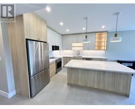 A modern kitchen with a stainless steel refrigerator and wooden cabinets.