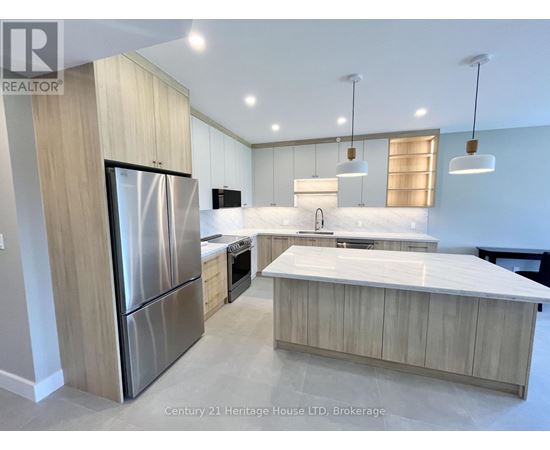 A modern kitchen with a stainless steel refrigerator and wooden cabinets.
