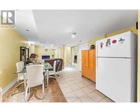 A kitchen with a white fridge and a dining table with chairs.