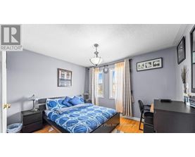 A bedroom with a bed, nightstand, and chair.