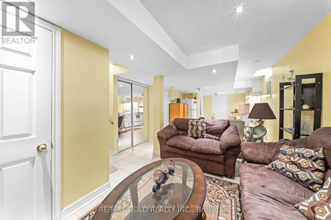 A living room with a brown couch and a glass table.