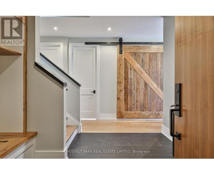 A hallway with a wooden door and a staircase.