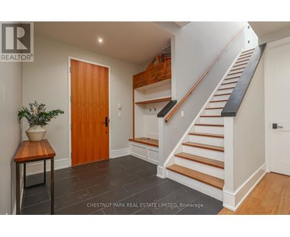 A wooden door is in a white hallway.