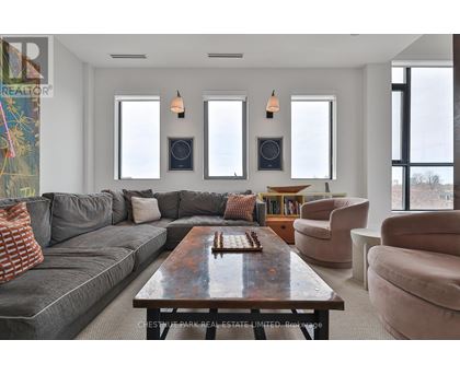 A living room with a grey couch, a wooden coffee table, and a large window.