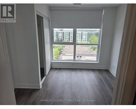 A room with a large window overlooking a parking lot.