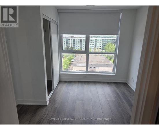 A room with a large window overlooking a parking lot.