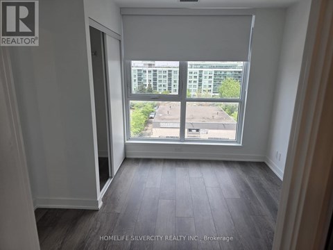 A room with a large window overlooking a parking lot.