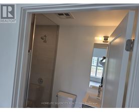 A bathroom with a toilet, sink and shower.