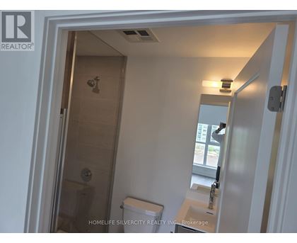 A bathroom with a toilet, sink and shower.