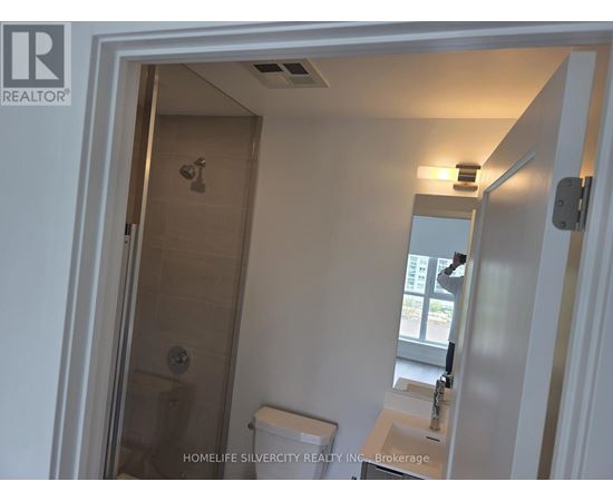A bathroom with a toilet, sink and shower.