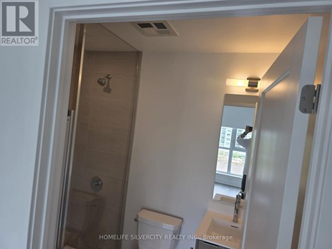 A bathroom with a toilet, sink and shower.