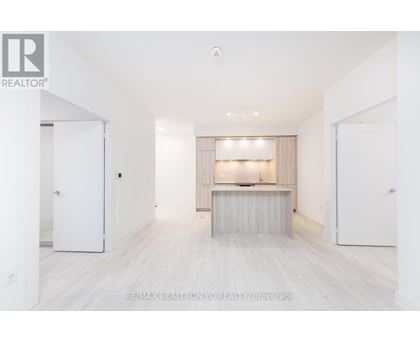 A spacious, empty room with a long table and a window with blinds.