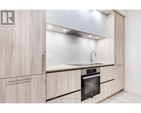 A modern kitchen with wooden cabinets and a stainless steel oven.