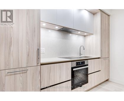 A modern kitchen with wooden cabinets and a stainless steel oven.
