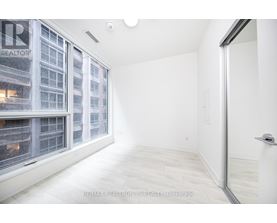 A white room with a window overlooking a building with the logo RE/MAX Realty YC Realty Brokerage.