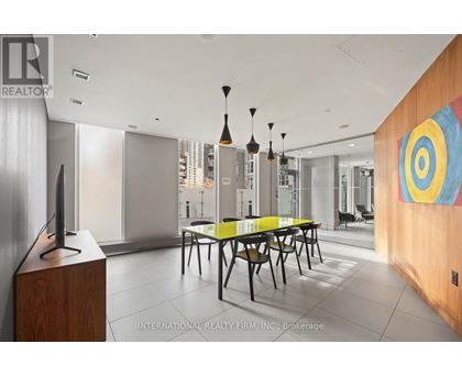 A modern dining room with a wooden table and chairs.