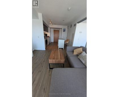 A living room with a grey couch and a wooden table.