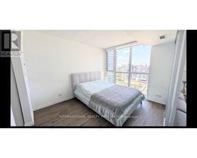 A bedroom with a large bed and a view of the city.