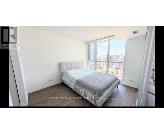A bedroom with a large bed and a view of the city.