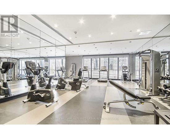 A gym with a variety of equipment including treadmills, weights, and exercise machines.