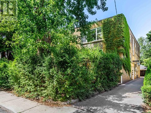 A building with a green plant on the side.