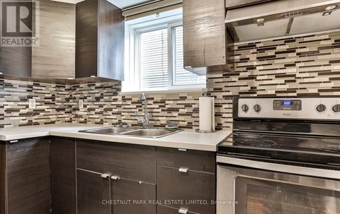 A modern kitchen with a stove top oven and a sink.