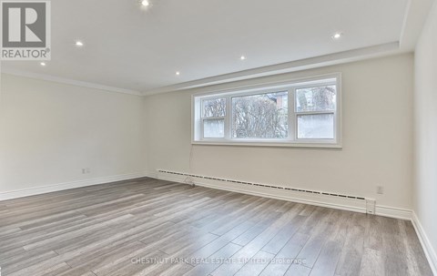 A room with a large window and wooden flooring.