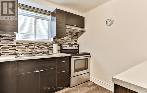 A kitchen with a stone backsplash and a stove top oven.