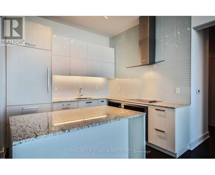 A kitchen with white cabinets and a granite countertop.