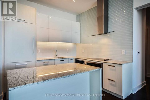 A kitchen with white cabinets and a granite countertop.