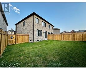 A house with a wooden fence and a green lawn in front.