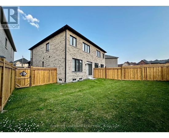 A house with a wooden fence and a green lawn in front.