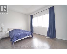 A bedroom with a bed, nightstand, and window.