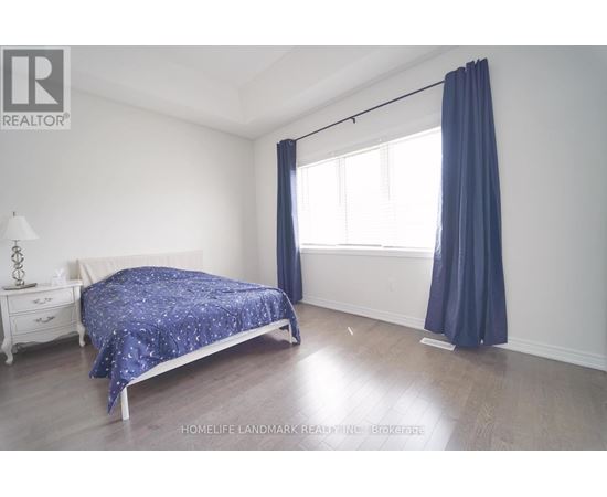 A bedroom with a bed, nightstand, and window.