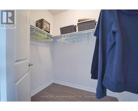 A white closet with a coat hanging on a rod.