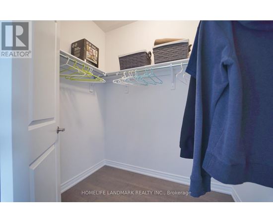 A white closet with a coat hanging on a rod.