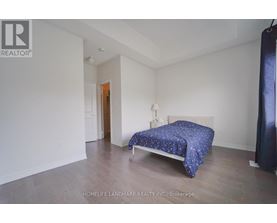 A bedroom with a bed and a blue bedspread.
