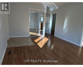 A room with wooden flooring and a sliding glass door.
