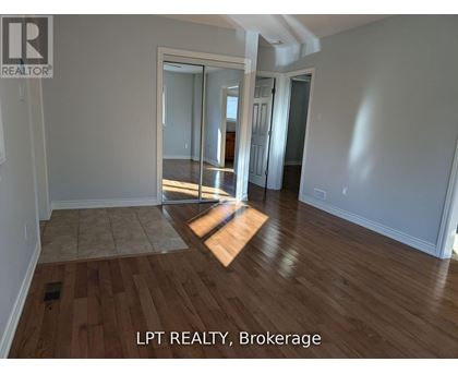 A room with wooden flooring and a sliding glass door.